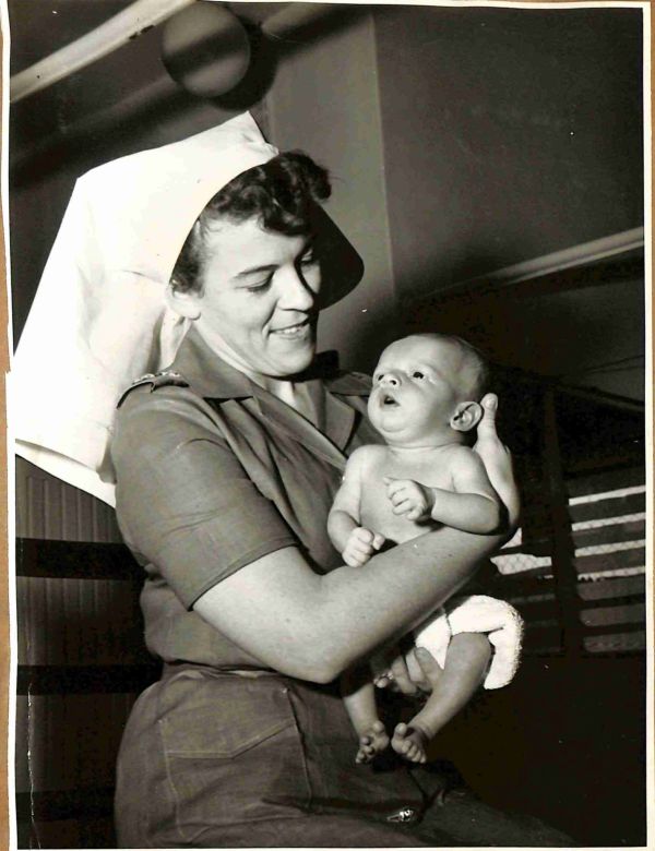 1957 Lt Margaret Gilbert, NSW, nurses the youngest patient at BMH Kamunting, Malaya.