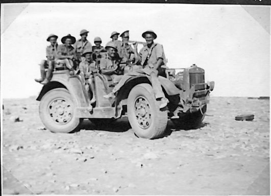 a captured Italian four wheel drive battle waggon. Left to right -Alf Gallaway, Tich Carlisle, George Bishop, Jock McGuire, George Skipworth, Archie Russell, Tom Hannah, Doug Ervine and Bill Montague